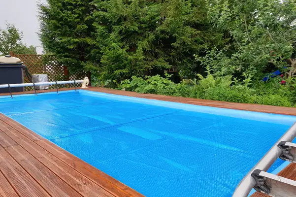 Blaue Sommerabdeckung auf einem rechteckigen Gartenpool
